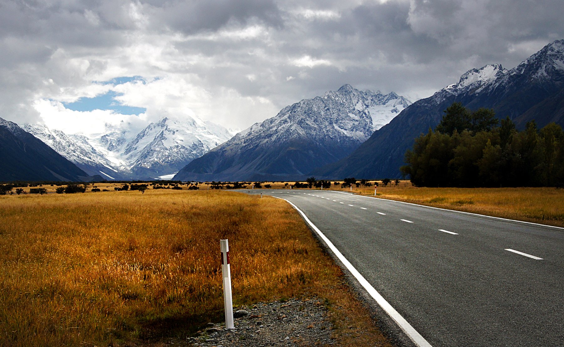 Open Road Toward Snowcapped Mountains
