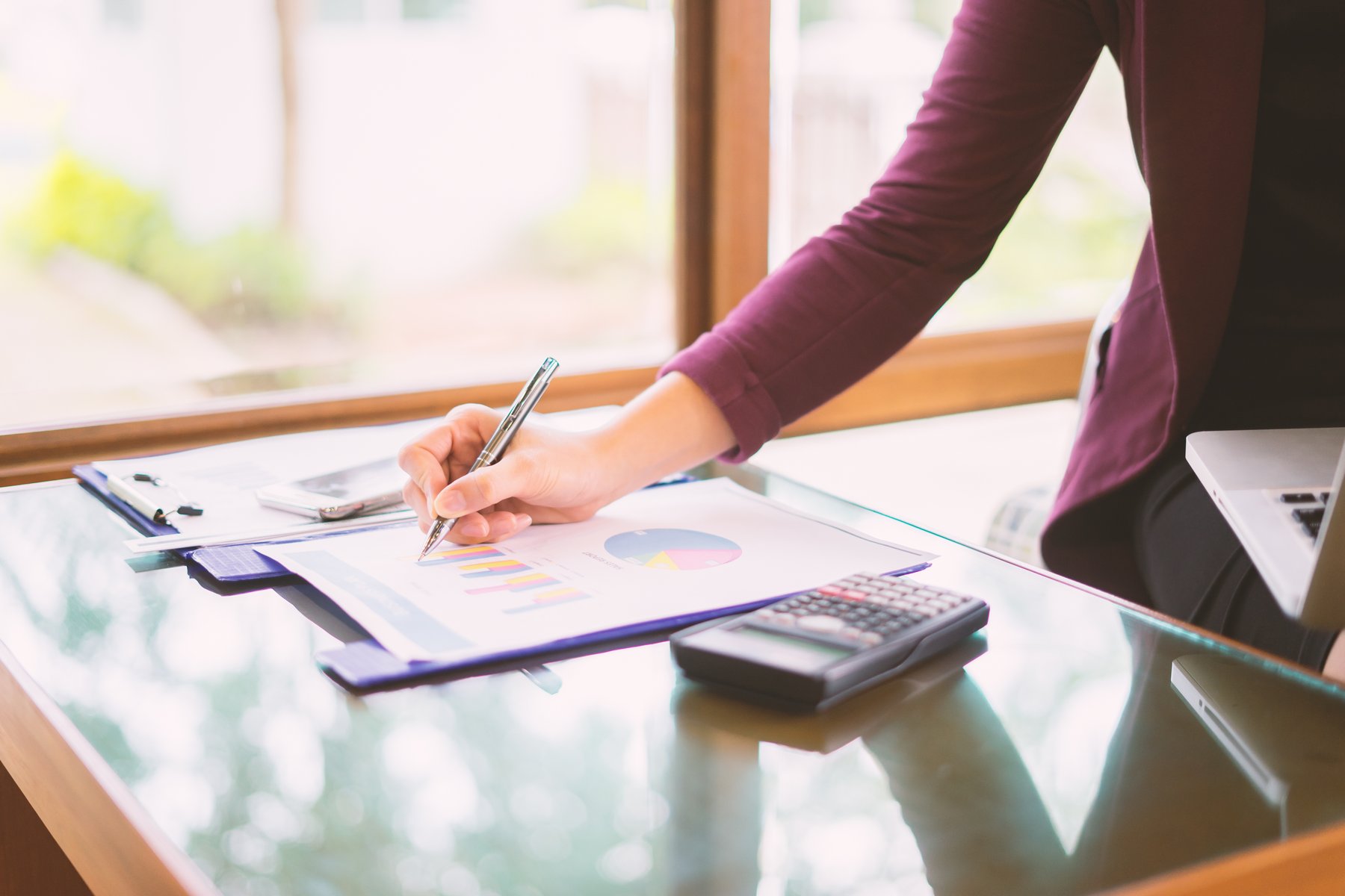 Writing Notes at a Glass Desk